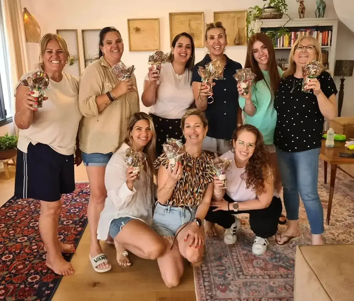 המשתתפות עומדות יחד ומציגות את יצירות השוקולד שלהן.