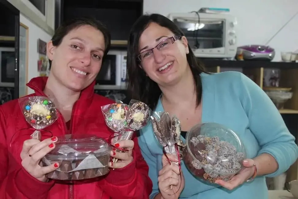 סדנת שוקולד בעינביז שוקולד - זוג משתמש בתבניות ליצירת שוקולדים.