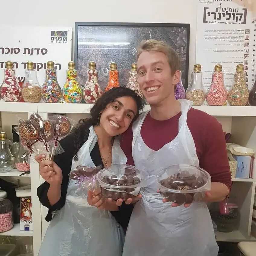 בני זוג מעטרים שוקולדים עם דוגמאות ייחודיות.