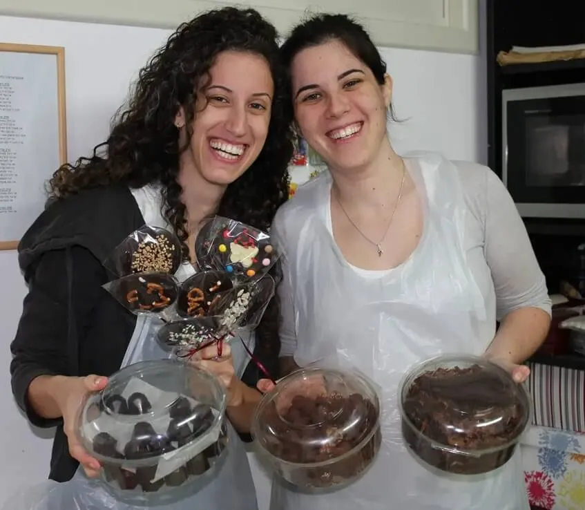 גבר ואישה מתאימים את הפרלינים שהם יצרו אחד לשני.