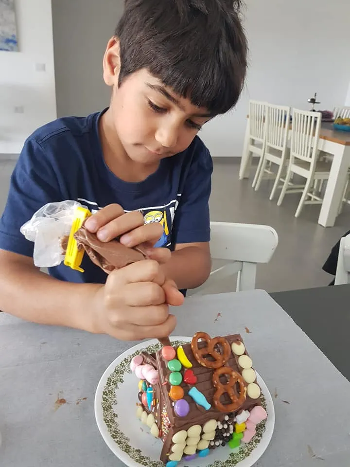 ילד מקשט בית שוקולד