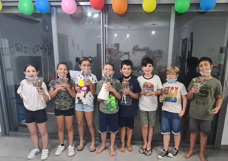 ילד קטן יוצר פרלינים בסדנת שוקולד מותאמת לילדים.