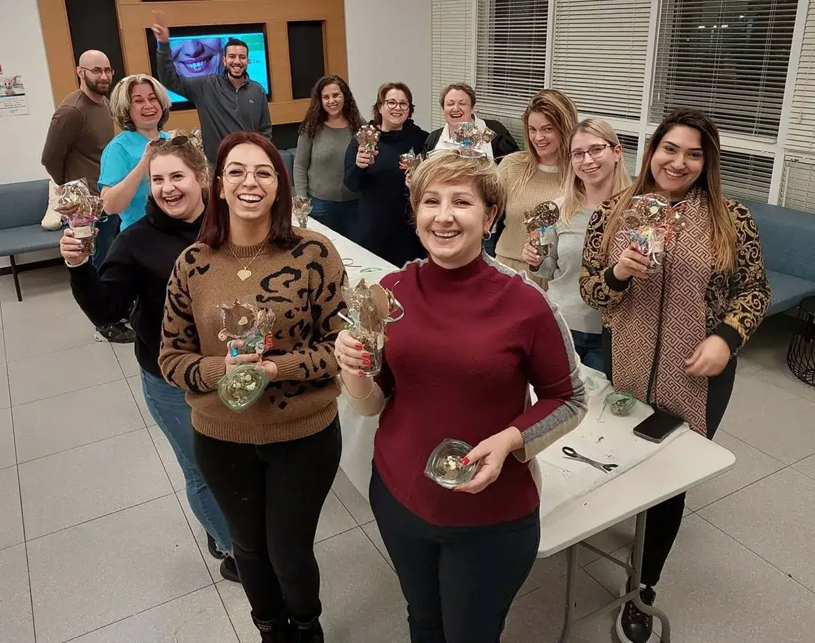קבוצת עובדים מחזיקה תוצרים של שוקולדים שיצרו יחד.