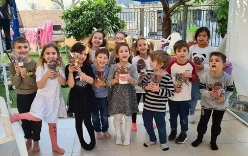 ילדים מחזיקים חטיפי שוקולד שהכינו בסדנת שוקולד לילדים של עינביז שוקולד